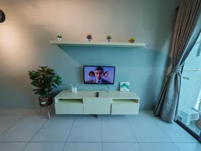 a living room with a tv on a blue wall at Modern Comfy Suite Room-9Pax in Perai