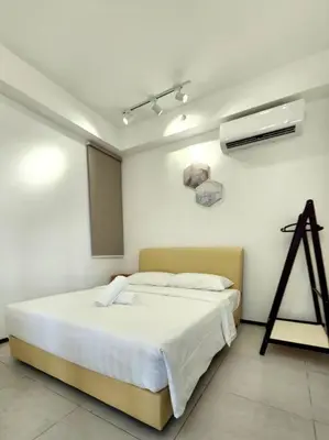 a white room with a bed and a fan at Urban Muji Retreat Suites #3BR #2carparks in Jelutong