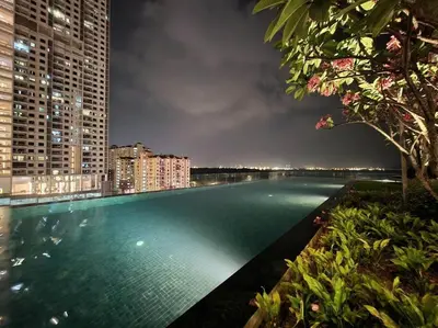 a swimming pool in the middle of a city at night at Urban Muji Retreat Suites #3BR #2carparks in Jelutong