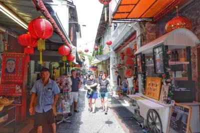 a group of people walking down a street in a market at 6-7Pax 3BR Waterpark Condo W Ps4 Near Ipoh Town in Kampong Pinji