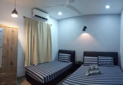 a bedroom with two beds with a teddy bear sitting on them at Pantai Remis Homestay 118A in Pantai Remis