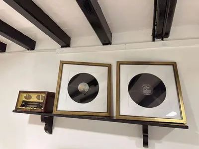 two framed pictures of records on a shelf at The Family Suit in George Town