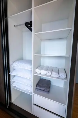 a closet with white shelves and folded towels at Beacon Suites #Georgetown #RoofTopPool #23 #2Bedrooms in George Town