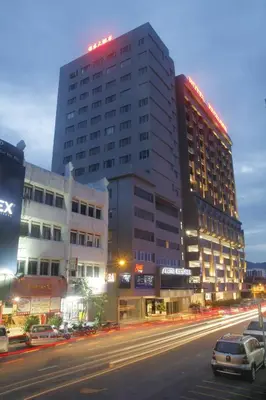 a large building on a city street at night at Hotel Excelsior Ipoh in Ipoh