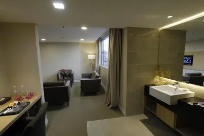 a bathroom with a sink and a living room at Hotel Excelsior Ipoh in Ipoh