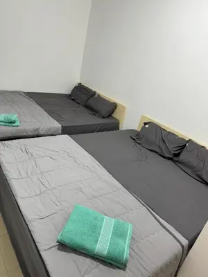 two beds sitting next to each other in a room at Jc Homestay in Ipoh