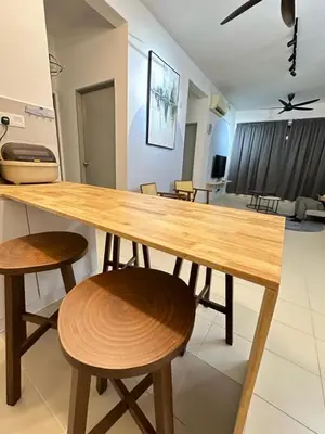 a wooden table with two chairs and a living room at Jc Homestay in Ipoh