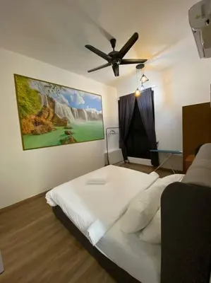 a bedroom with a bed with a painting on the wall at Modern Lux Suite, The Cove Hillside Residence in Ipoh