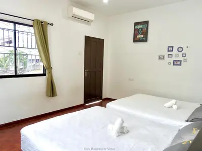 two white beds in a room with a window at Ipoh Cozy Homestay for 10-13pax in Ipoh