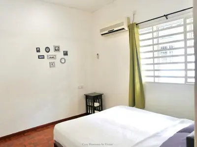 a white bedroom with a bed and a window at Ipoh Cozy Homestay for 10-13pax in Ipoh