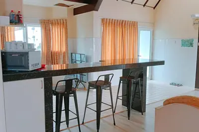 a kitchen with a counter with stools and a microwave at Silverpart Resort Fraser Hill C3-6-2 Forest View High Floor No lift in Bukit Fraser