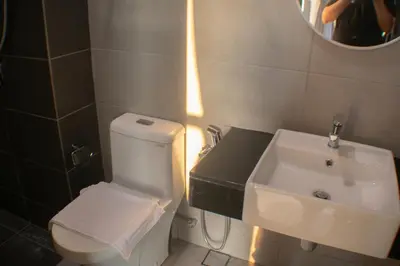 a bathroom with a white toilet and a sink at Prime Comfort Seaview with Netflix and Water Filter near Georgetown in Jelutong