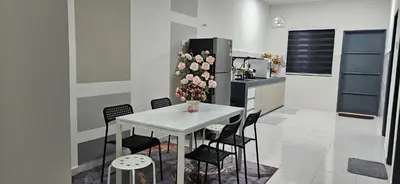 a kitchen with a white table with chairs and flowers at TELUK INTAN LANDED LUXURY HOMESTAY 3BEDROOM in Teluk Intan