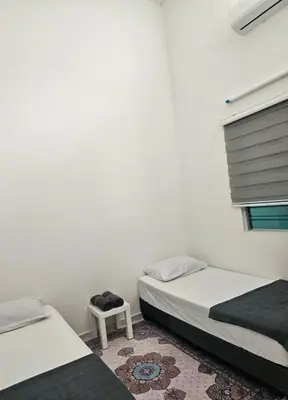 a bedroom with two beds and a table and a window at TELUK INTAN LANDED LUXURY HOMESTAY 3BEDROOM in Teluk Intan