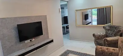 a living room with a television and a chair at TELUK INTAN LANDED LUXURY HOMESTAY 3BEDROOM in Teluk Intan