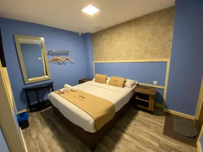 a bedroom with a large bed in a blue room at Suria Cameron Hotel in Tanah Rata