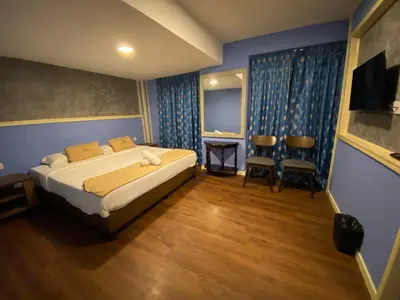 a bedroom with a bed and two chairs in it at Suria Cameron Hotel in Tanah Rata