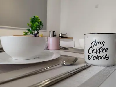 a coffee cup and a plate and spoon on a table at Cityscape Suite, 4 to 5 Pax at Urban Suites Georgetown by SuperStay in Jelutong