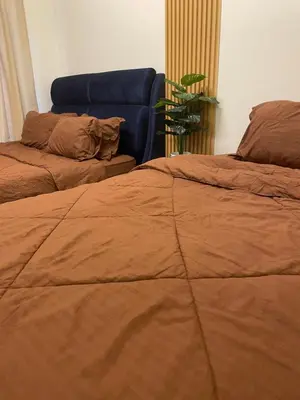 a bedroom with two beds and a blue couch at Orked Homestay Bagan Serai in Bagan Serai