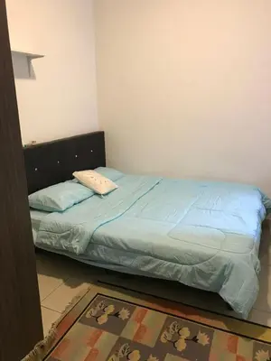 a bedroom with a bed with blue sheets and a rug at Palas Horizon in Kabus in Brinchang