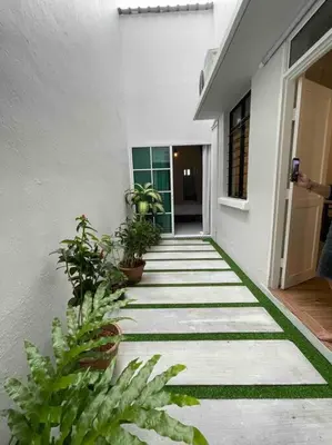 a walkway with plants on the side of a building at Modern Victorian Homestay in Jelutong