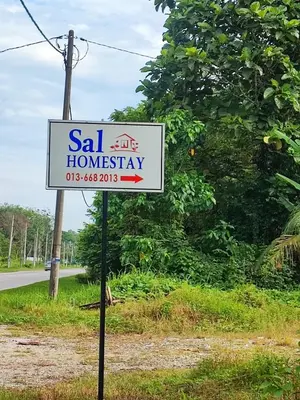 a sign for a salt homesteadery on the side of a road at Sal Homestay in Slim River