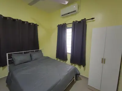 a bedroom with a bed with purple curtains and a window at Sal Homestay in Slim River