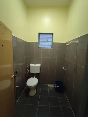 a bathroom with a toilet and a window at Sal Homestay in Slim River