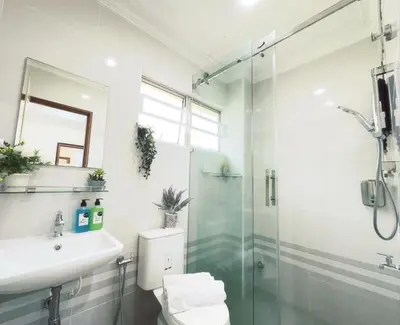 a bathroom with a shower and a toilet and a sink at Sunway Alpine Suites near Onsen and Themepark Tambun Ipoh by IWH in Ipoh