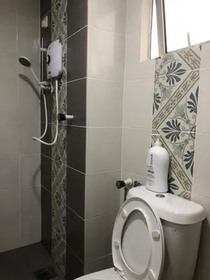a small bathroom with a toilet and a shower at Ipoh Anderson Suites by Migliore in Ipoh