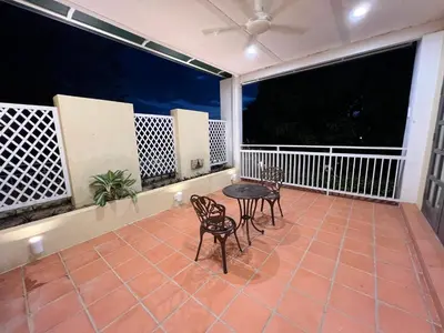 a patio with two chairs and a table on a balcony at THE GARDEN SUITE in Balik Pulau