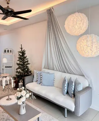 a living room with a couch and a christmas tree at Blubelle Apt Near Lake Garden Zoo With Wifi Netflix in Taiping
