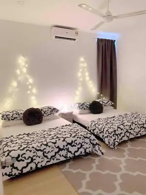 two beds in a room with lights on the wall at Blubelle Apt Near Lake Garden Zoo With Wifi Netflix in Taiping