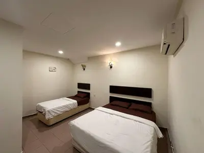 a bedroom with two beds and a television in it at Ezzy In Hotel in Seri Manjung