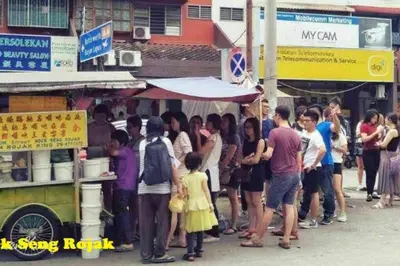 a group of people standing in front of a street vendor at Georgetown, Up to 5 Pax, 2 Bedrooms, 1 Bathroom, 1 Car Park by Star Home in George Town