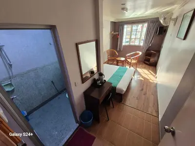 a bedroom with a bed and a mirror in a room at Hotel Sentosa in Brinchang