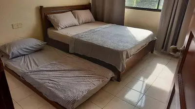 two twin beds in a room with a window at Seaput Srisayang in Batu Ferringhi