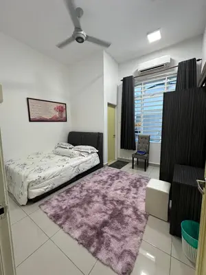 a bedroom with a bed and a purple rug at Nurasyura Puncak Guesthouse in Seri Iskandar