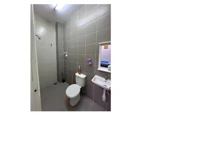 a bathroom with a toilet and a sink at Nurasyura Puncak Guesthouse in Seri Iskandar