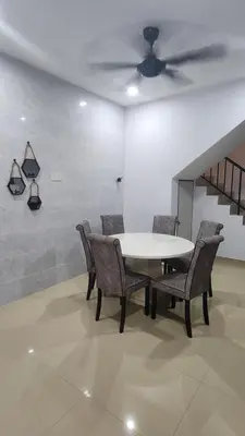 a table and chairs in a room with a ceiling fan at AY Homestay Midtown Falim in Ipoh