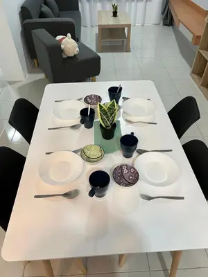 a white table with plates and utensils on it at Ipoh Town Anderson Haru Suite 7 paxs 2R2B in Ipoh