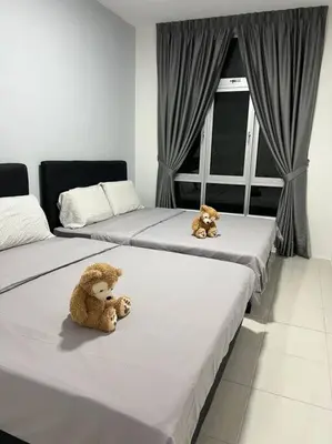 two teddy bears sitting on two beds in a room at Ipoh Town Anderson Hana Suite 7 paxs 2R2B in Ipoh