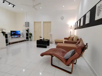 a living room with a couch and a tv at Sunway Tambun Salesman Stay 5 Bedroom 10pax by IWH in Ipoh