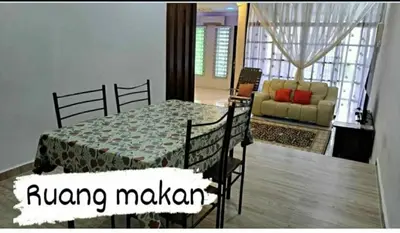 a bedroom with a bed and a living room with a couch at Homestay Mukhriz in Kulim