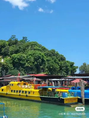 a yellow boat in the water next to a dock at Jo Jo Homestay @ Pangkor Coral Bay Resort in Pasir Bogak