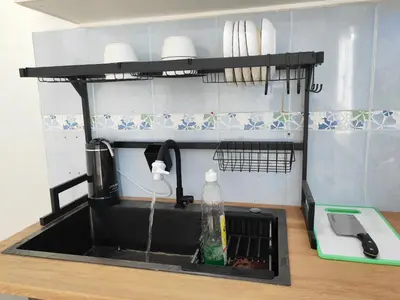 a kitchen sink with water coming out of it at Padang Serai Room Stay Share Bathroom in Padang Serai