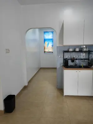 a kitchen with white cabinets and a tile floor at Padang Serai Room Stay Share Bathroom in Padang Serai