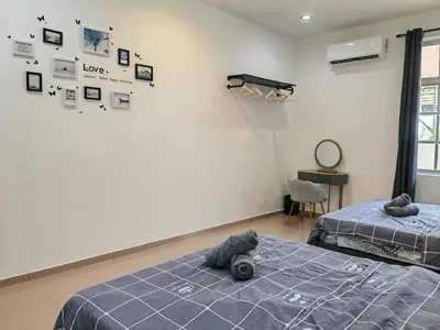 two beds in a room with pictures on the wall at Padang Serai Room Stay Share Bathroom in Padang Serai