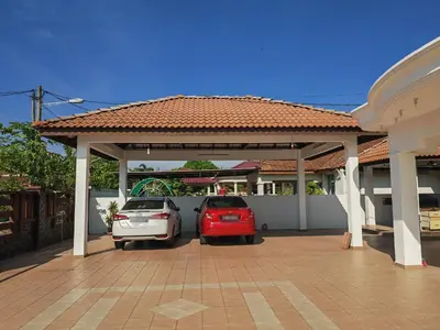 two cars parked under a carport in a house at Padang Serai Roomstay Family Suite Share Bathroom804 in Padang Serai