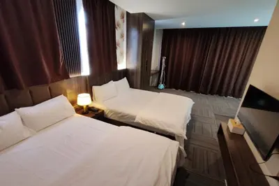 a hotel room with two beds and a television at Casa Colney Hotel Ipoh in Ipoh